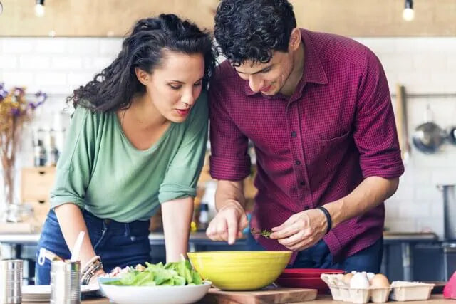 man and woman cooking together